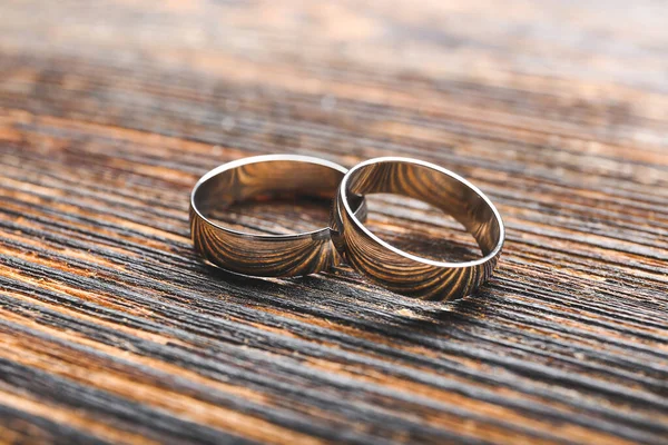 Pair of wedding rings on wooden background — 스톡 사진