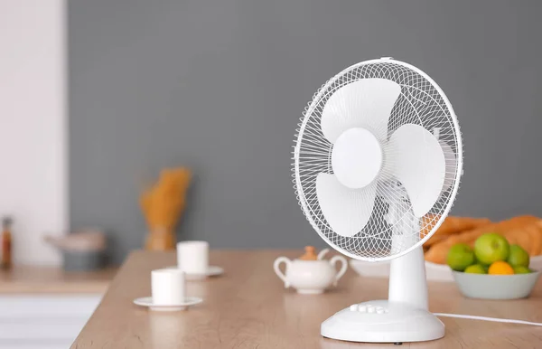 Electric fan on table in kitchen — Stock Photo, Image