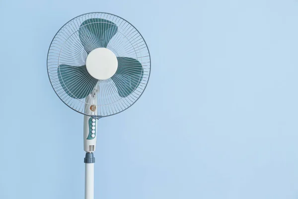 Modern electric fan on color background