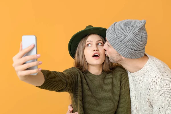 Casal jovem tomando selfie no fundo de cor — Fotografia de Stock