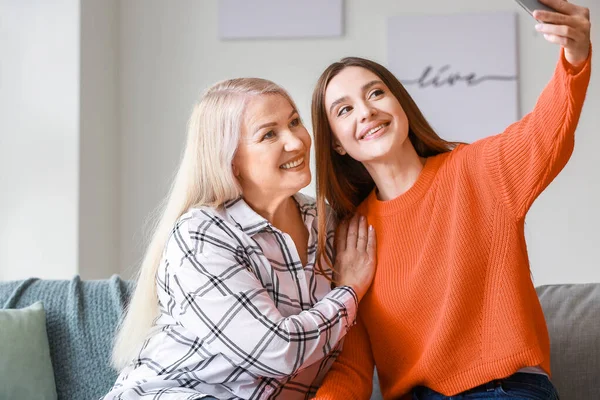 Young woman and mother taking selfie together at home — Stock Photo, Image