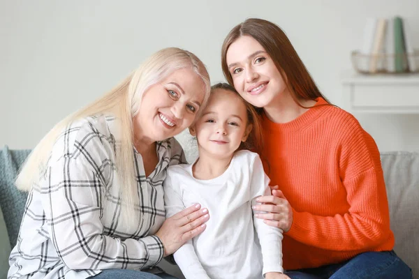 Jonge vrouw met haar kleine dochter en moeder brengen tijd samen door thuis — Stockfoto