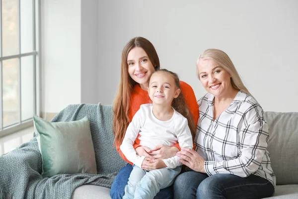 Jonge vrouw met haar kleine dochter en moeder brengen tijd samen door thuis — Stockfoto