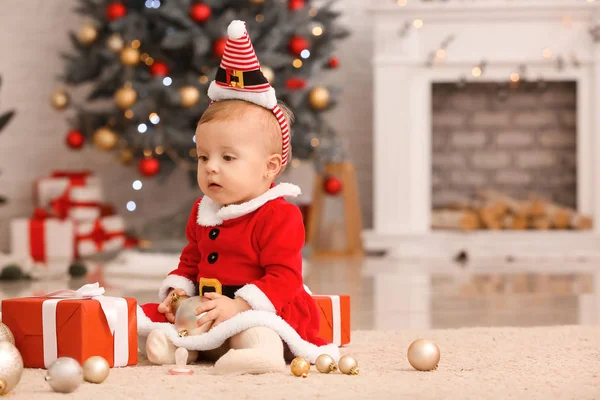 Bebê bonito em traje de Papai Noel e com presentes de Natal em casa — Fotografia de Stock