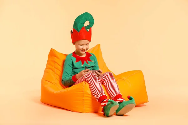 Little boy in costume and with mobile phone on color background — Stock Photo, Image