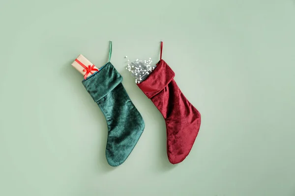 Karácsonyi zokni ajándékokkal lógó színes falon — Stock Fotó