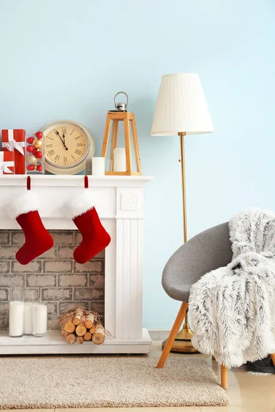 Weihnachtssocken mit Geschenken hängen am Kamin im Zimmer — Stockfoto