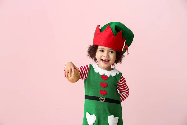 Bambina in costume da elfo e con palla di Natale su sfondo a colori — Foto Stock