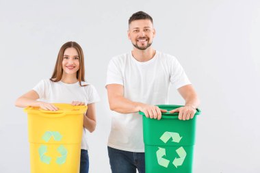 Arka planda çöp konteynırları olan bir çift. Geri dönüşüm kavramı