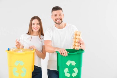 Arka planda çöp konteynırları olan bir çift. Geri dönüşüm kavramı