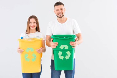 Arka planda çöp konteynırları olan bir çift. Geri dönüşüm kavramı