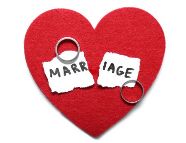 Kırmızı kalp, yırtık kağıt, evlilik ve hafif arka planda yüzükler. Boşanma kavramı