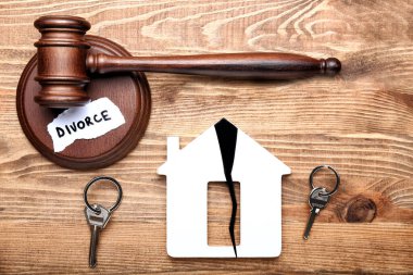 Yargıç tokmağı, ahşap arka planda çatlak ve anahtarlı ev figürü. Boşanma kavramı