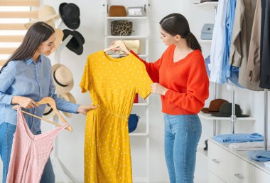 Young women choosing clothes in modern store