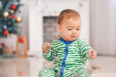 Noel için dekore edilmiş çelengi olan şirin bir bebek.