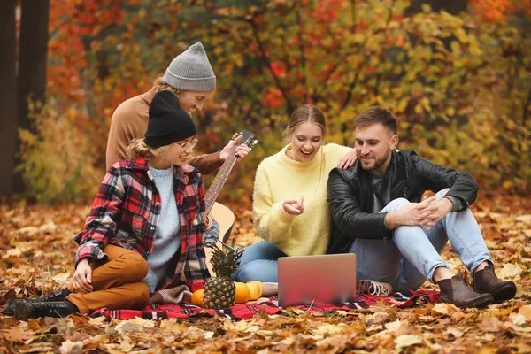 Happy young friends resting together in autumn park — Stock Photo, Image
