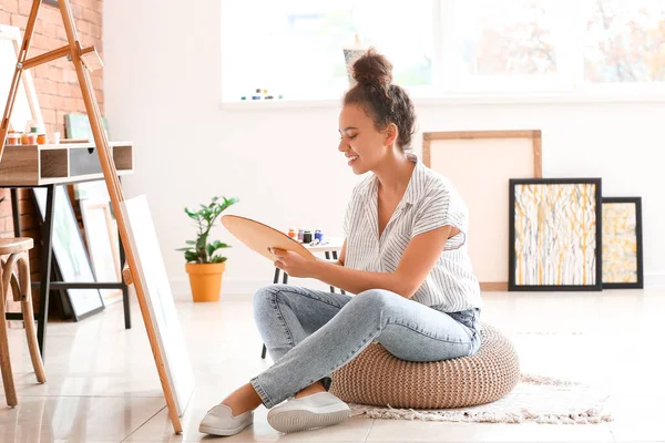 Beautiful female African-American artist painting in studio — Stock Photo, Image