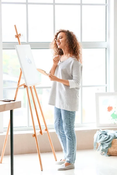 Beautiful female African-American artist painting in studio — Stock Photo, Image