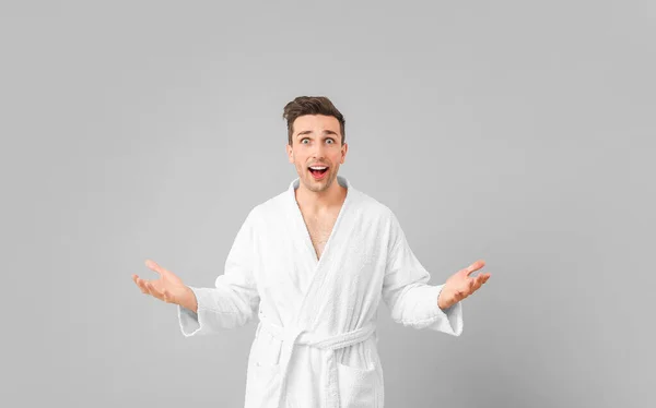Surprised man in bathrobe on grey background — Stock Photo, Image
