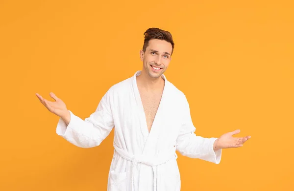 Handsome man in bathrobe on color background — Stock Photo, Image