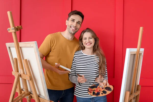 Paar junger Künstler auf farbigem Hintergrund — Stockfoto