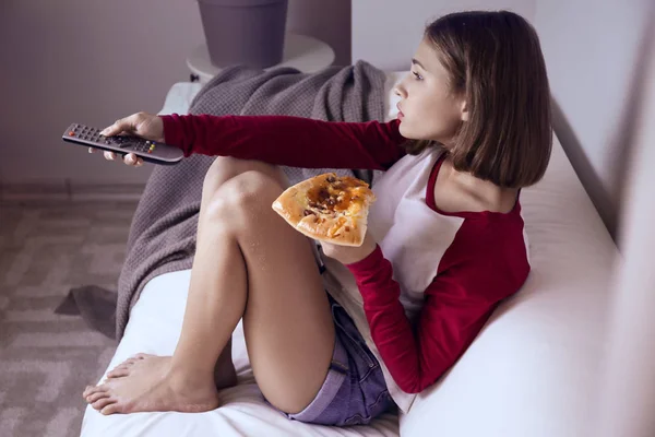 Adolescente comiendo pizza mientras ve la televisión tarde en la noche —  Fotos de Stock