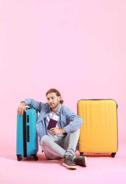 Young tourist with luggage on color background — Stock Photo, Image