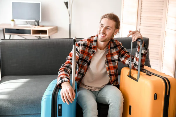 Young man with packed luggage at home — Stock Photo, Image