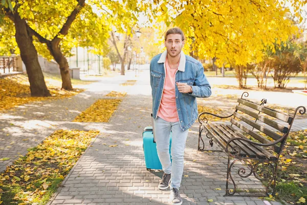 Hurrying young man with luggage outdoors — Stock Photo, Image