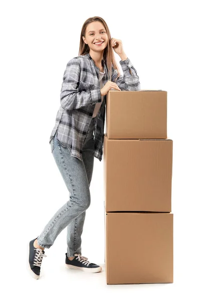 Young woman with moving boxes on white background — Stock Photo, Image