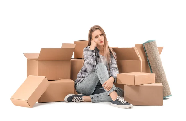 Beyaz arka planda kutuları taşıyan üzgün genç bir kadın. — Stok fotoğraf
