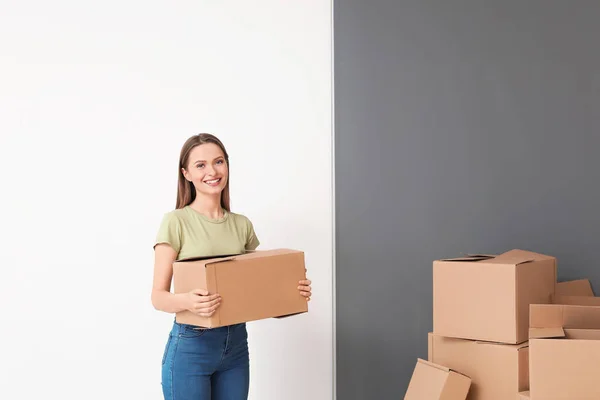 Mujer joven feliz con cajas móviles en casa nueva — Foto de Stock