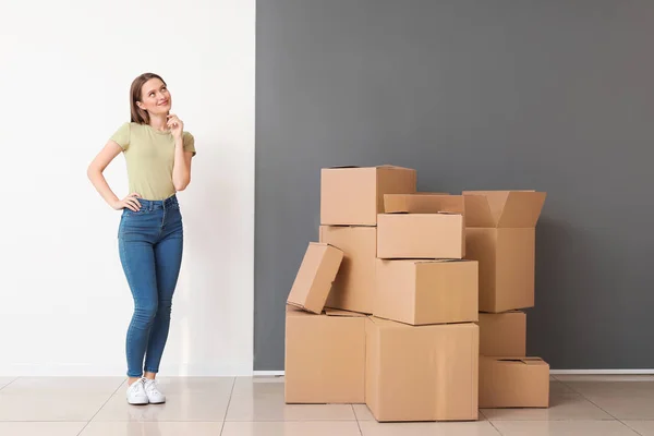 Zamyšlená mladá žena s pohyblivým box v novém domě — Stock fotografie