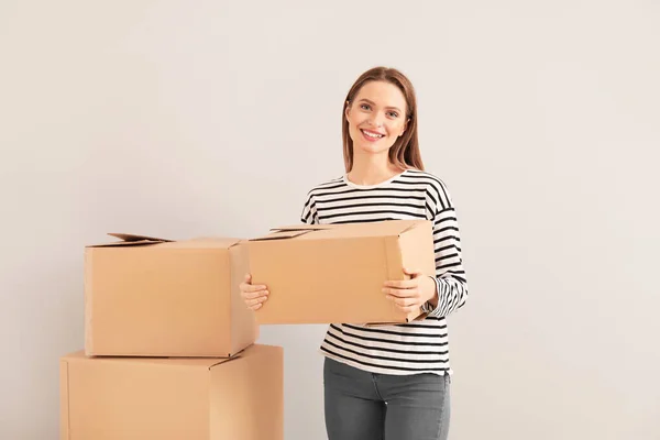 Boldog fiatal nő mozgó dobozok könnyű háttér — Stock Fotó