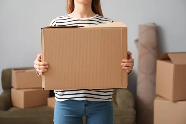 Jeune femme avec des boîtes de déménagement dans une nouvelle maison — Photo