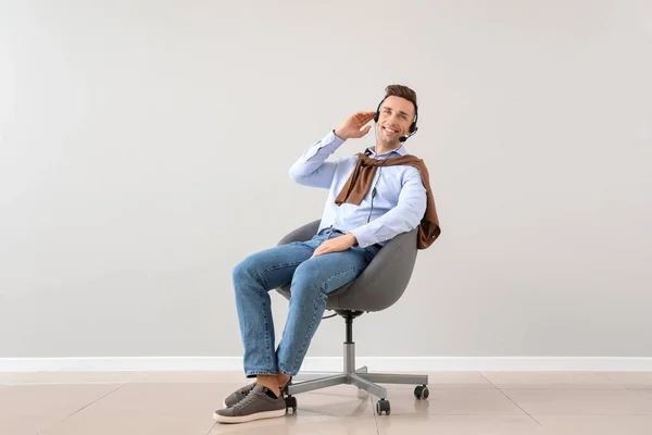 Male technical support agent on light background — Stock Photo, Image