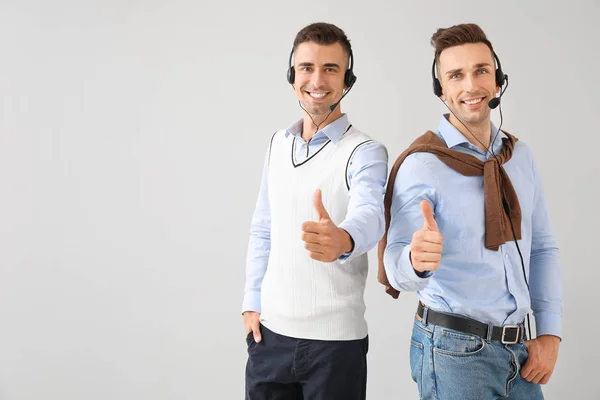 Team van technische ondersteuners met duimgebaar op lichte achtergrond — Stockfoto