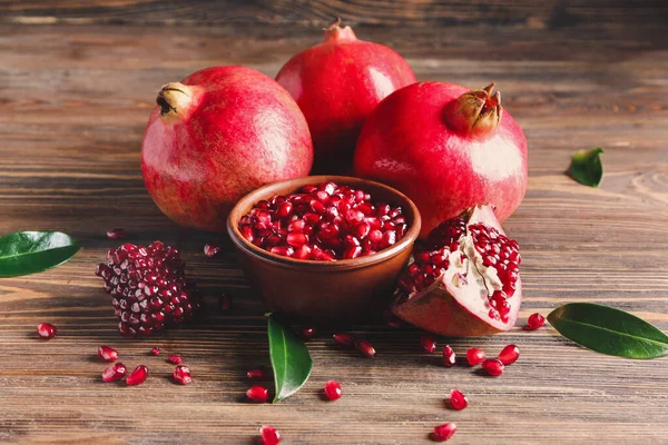 Bowl with tasty pomegranate on wooden background — Stock Photo, Image