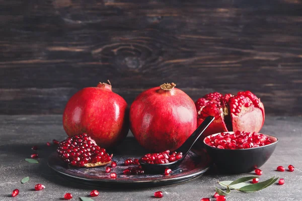 Plate with tasty pomegranate on dark background — Stock Photo, Image