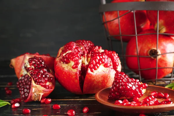 Tasty pomegranate on dark wooden table — Stock Photo, Image