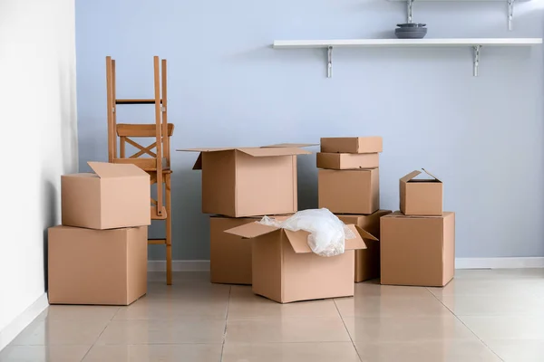 Kartonnen dozen met bezittingen in nieuwe flat op verhuisdag — Stockfoto