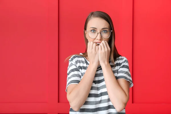 Worried young woman on color background — Stock Photo, Image