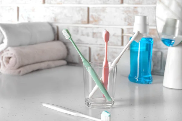 Holder with tooth brushes on table in bathroom — Stock Photo, Image
