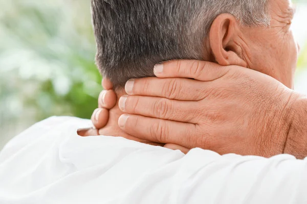 Mature man suffering from neck pain at home, closeup — Stock Photo, Image