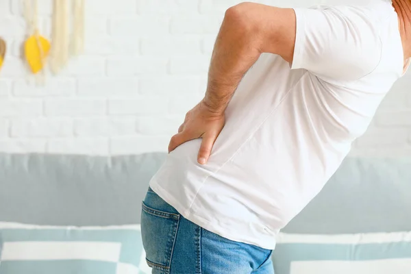 Mature man suffering from back pain at home