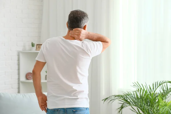 Älterer Mann leidet zu Hause unter Nackenschmerzen — Stockfoto