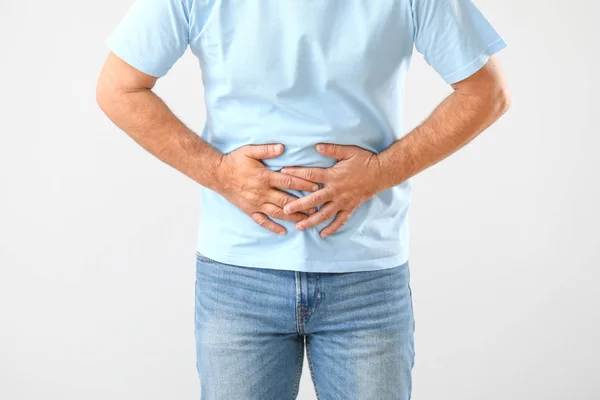 Mature man suffering from abdominal pain on white background — Stock Photo, Image