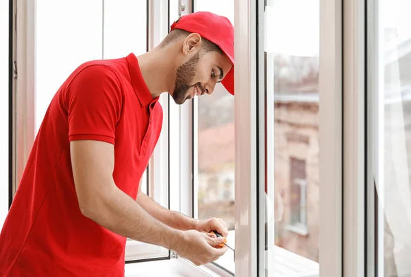 Trabajador joven instalando ventana en piso — Foto de Stock