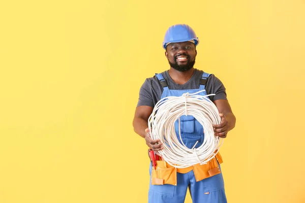 Elettricista afro-americano su sfondo a colori — Foto Stock