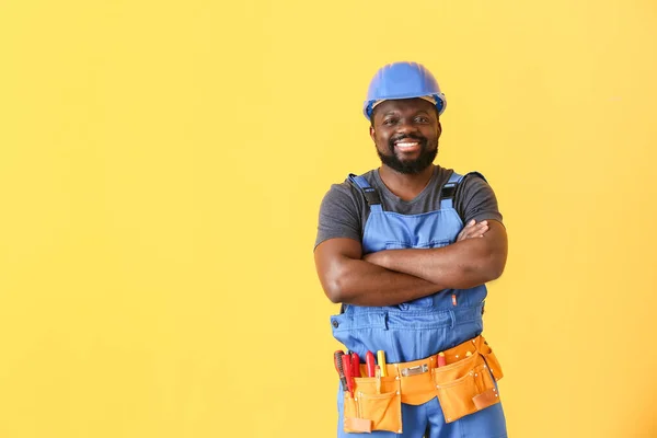 African-American electrician on color background